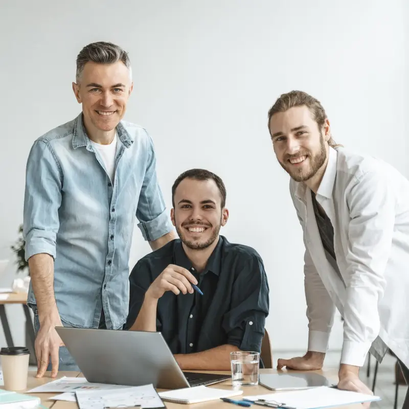 Three professionals collaborating and analyzing data on a laptop